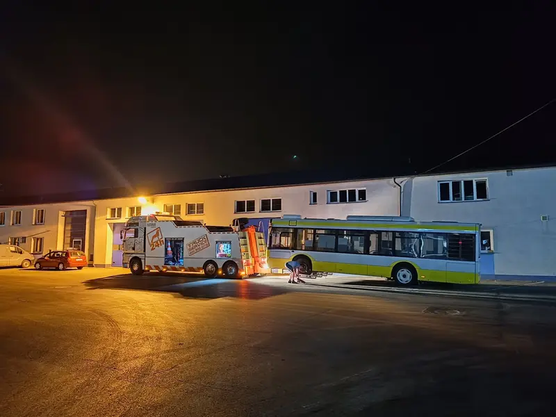 Pracownik S-Trans podpina autobus miejski do holownika nocą