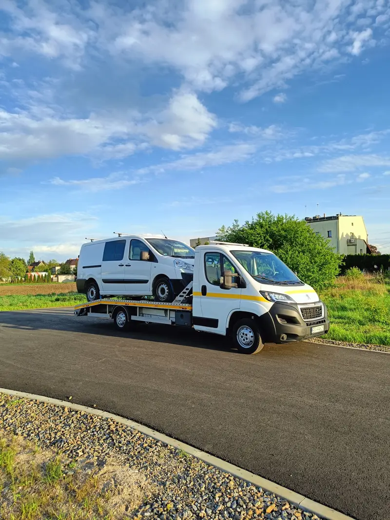 Laweta S-Trans przewożąca białego busa dostawczego